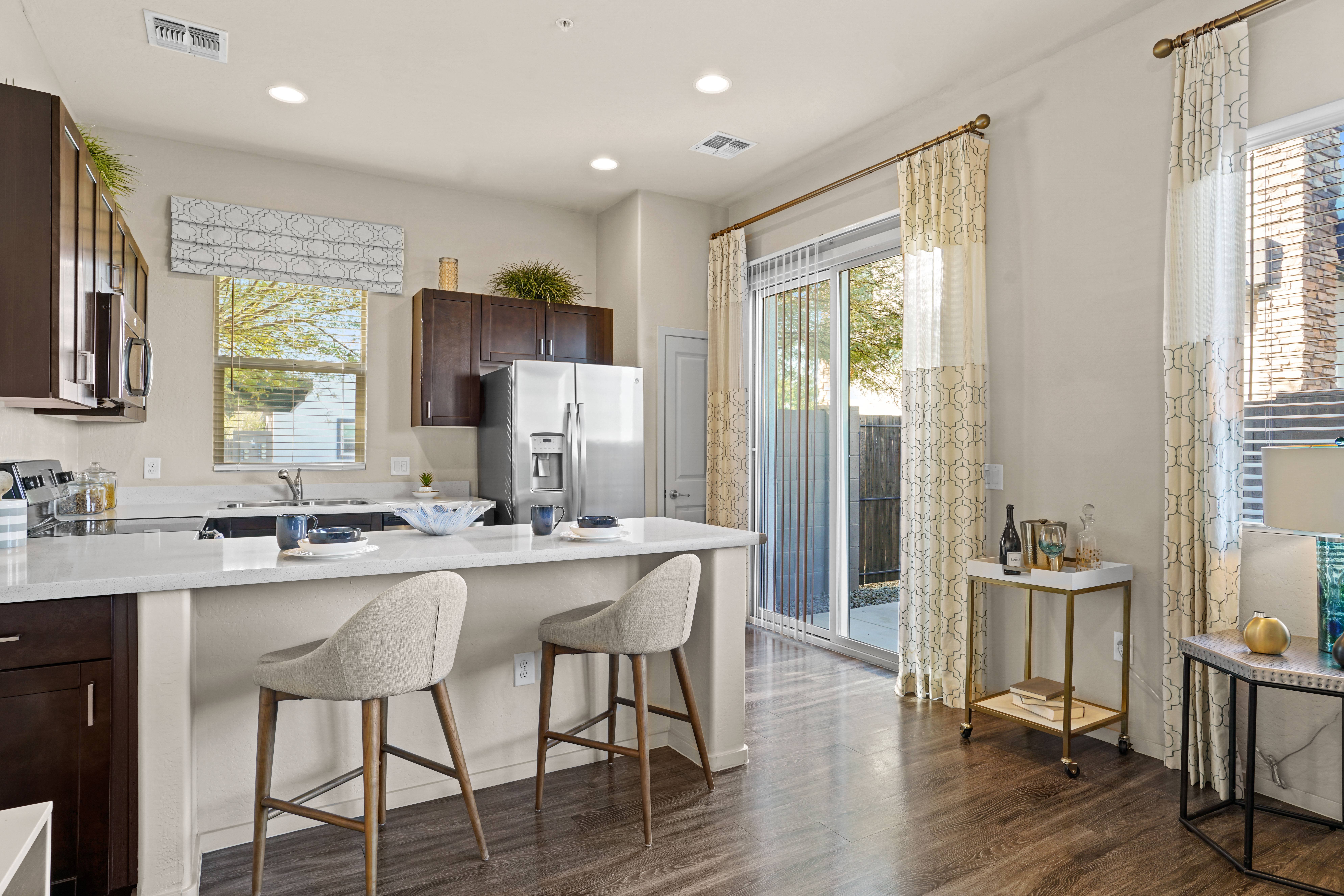 a kitchen with an island and a door to a patio at Olive Queen Creek Apartments, Arizona